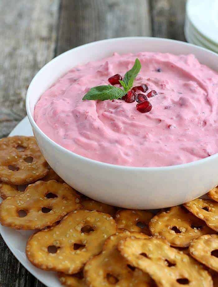 Cranberry Basil Dip on white plate with flat pretzel chips