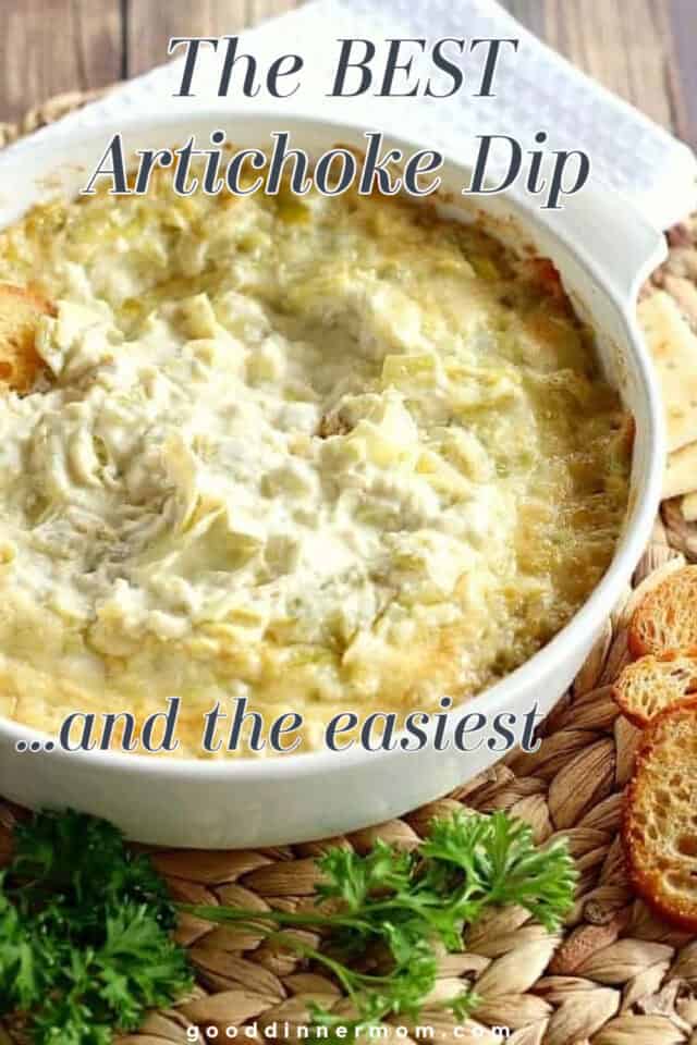 Artichoke dip in a serving and baking bowl with crackers and bread on side.