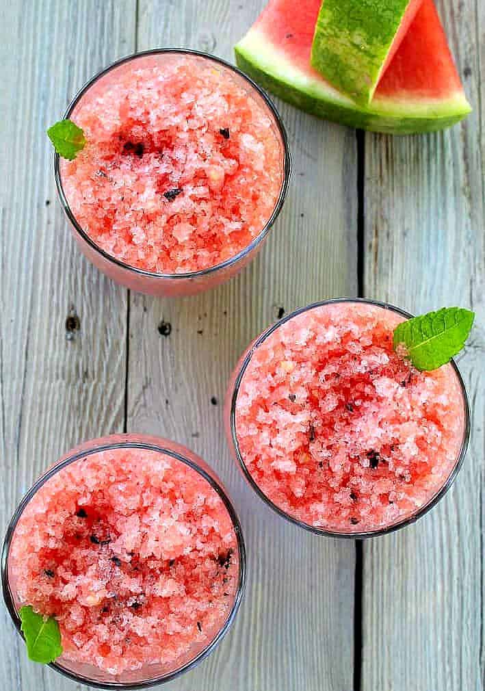 Watermelon Granita with Black Lava Salt in three glasses with watermelon slices on the side