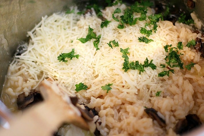 mushroom risotto with Parmesan cheese being stirred 