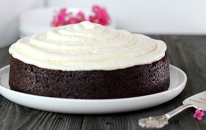 Chocolate Stout Cake with Irish Cream Frosting on a white plate with serving spoon 