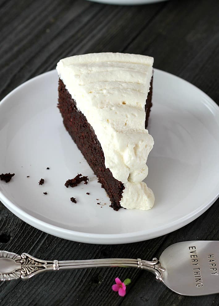 one slice of frosted stout cake on a white plate