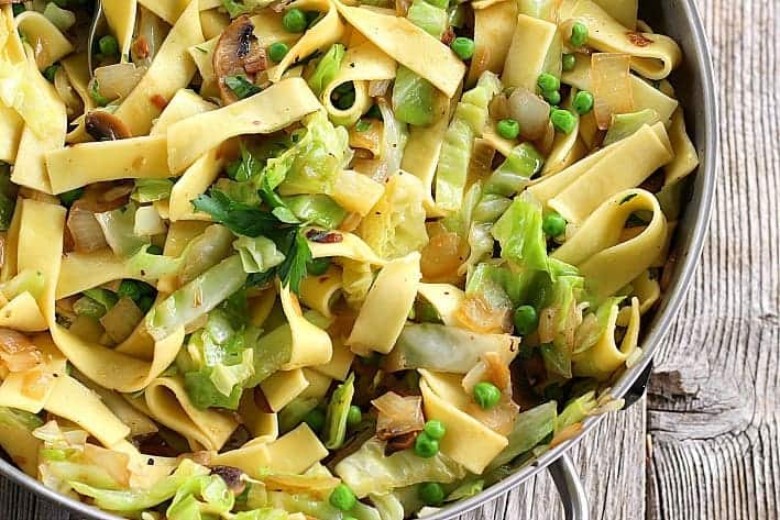 Close up of cabbage and noodles with mushrooms, peas in pot