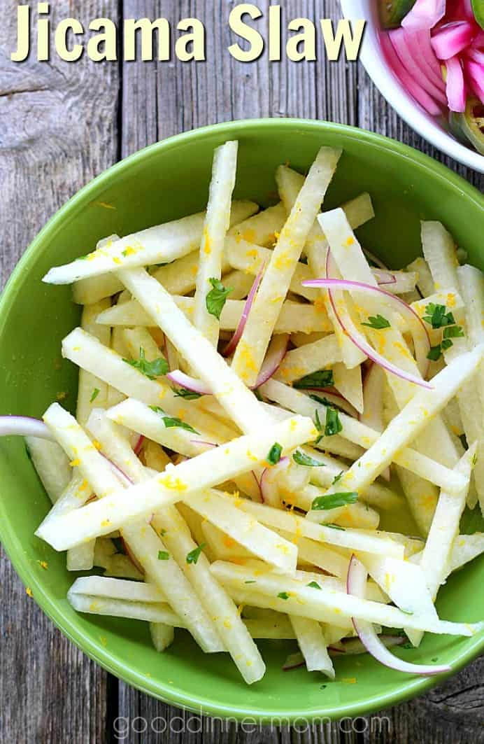 Delicate flavored jicama pairs with bold red onion, bright cilantro, and fresh orange juice and zest for a simple, crunchy salad-slaw that pairs with any tacos or fajitas. #jicama #slaw #tacos