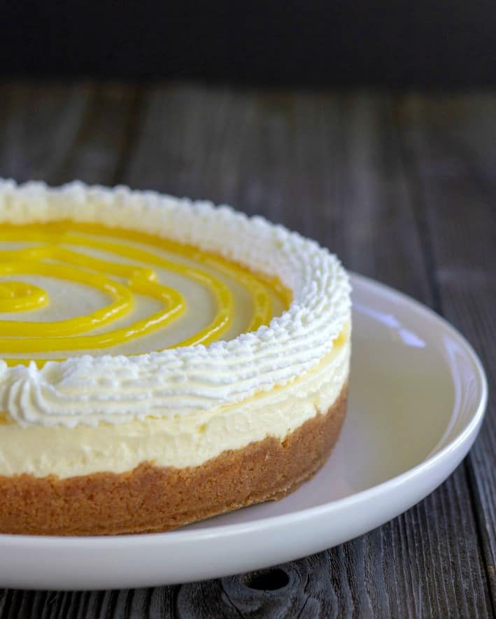 no bake cheesecake with whipped topping and lemon curd on a white plate