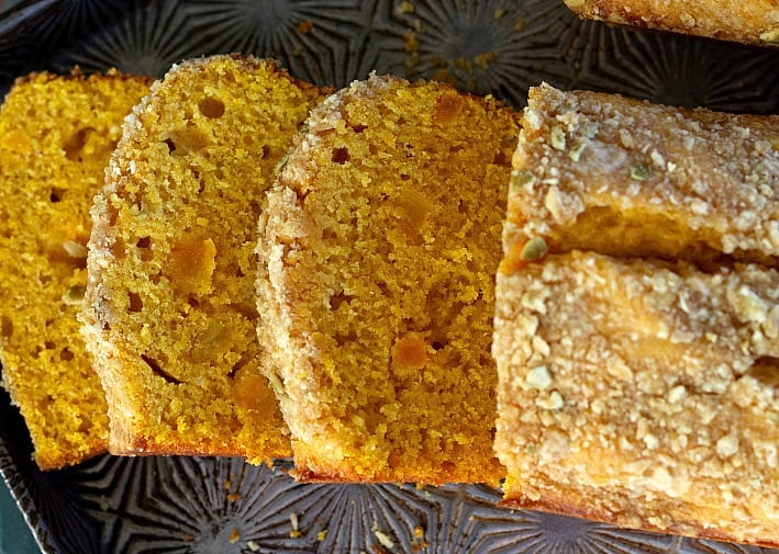 Apricot pumpkin bread slices on black plate