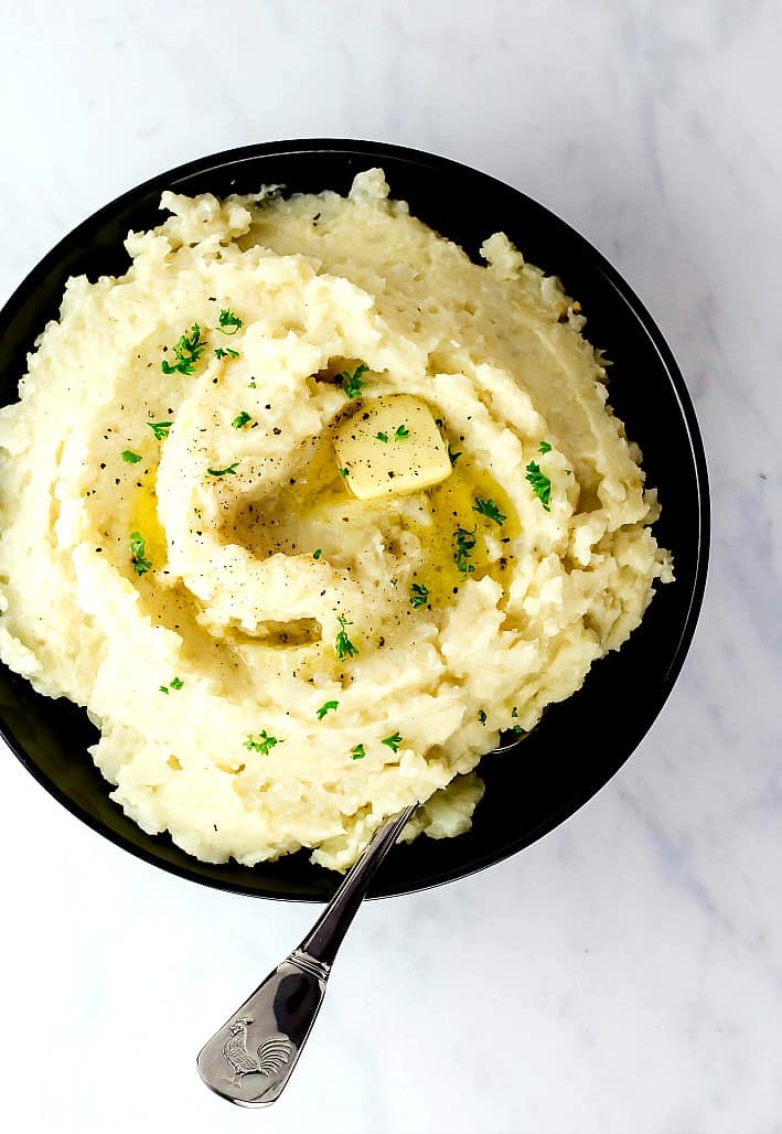 Mashed cauliflower and potatoes served in a black bowl