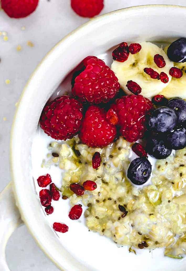 Close up of porridge with berries and bananas in a white bowl 