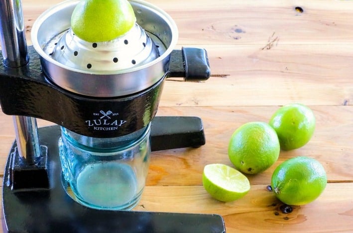 limes being juiced with a juicer 