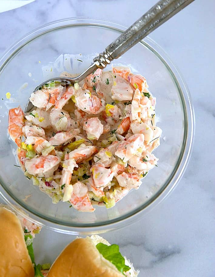 Shrimp salad in a glass bowl with a spoon