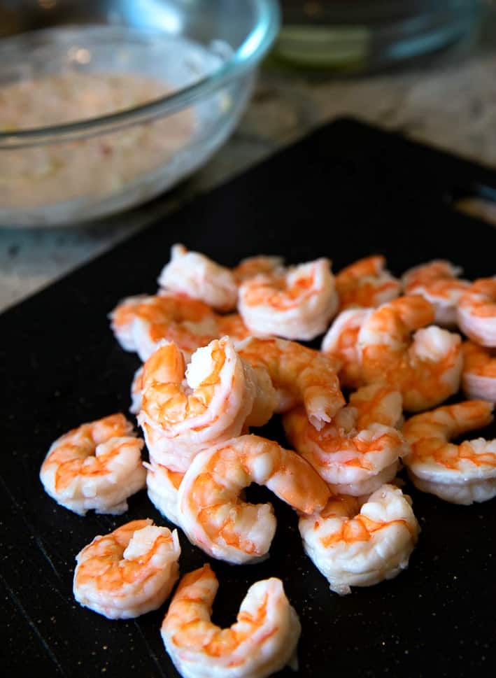 cooked shrimp on a black cutting board