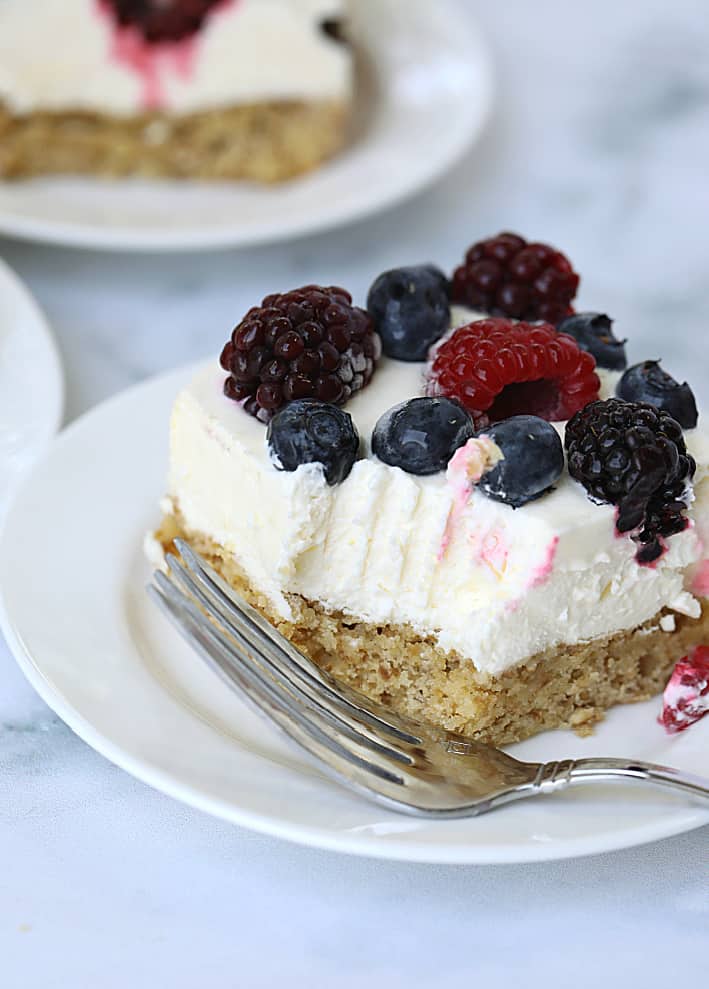 Easy cheesecake bars with berries on top with a bite taken out of it