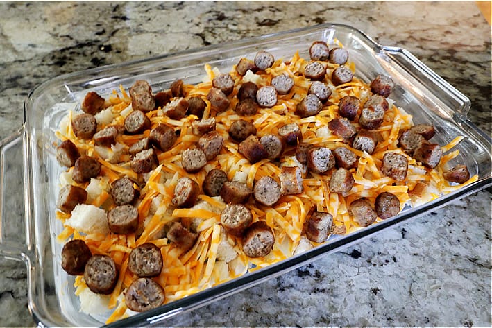 9x13 pan with cubed bread, grated cheese, sausage on top