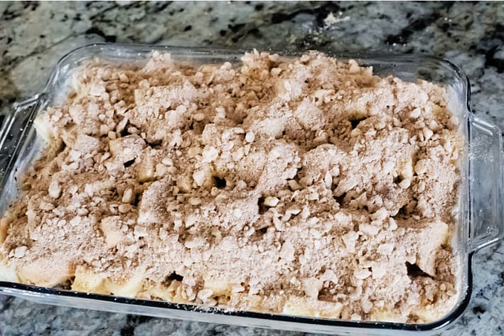 A mixture of flour, brown sugar, cinnamon, nutmeg and cold butter on top of casserole before baking