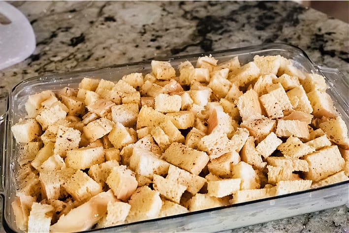 Cubed French bread, eggs, milk and spices in a glass baking dish