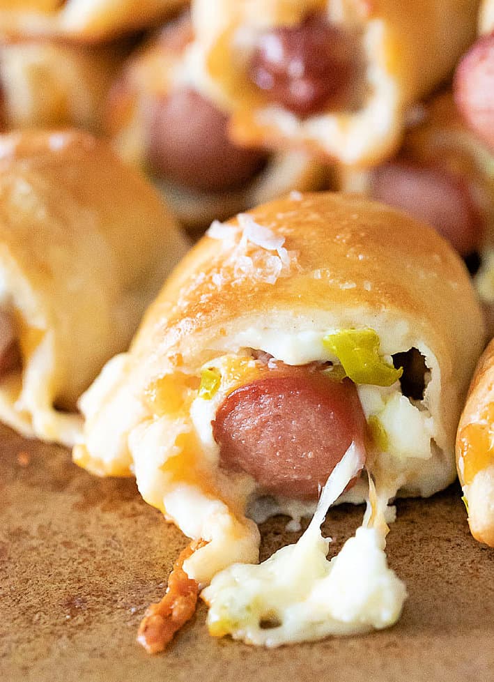 Close up of jalapeno popper pigs in a blanket with cheese and diced pickled jalapenos.
