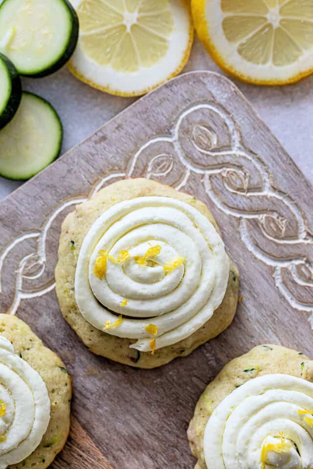 Lemon zucchini cookie with lemon buttercream frosting on wood board