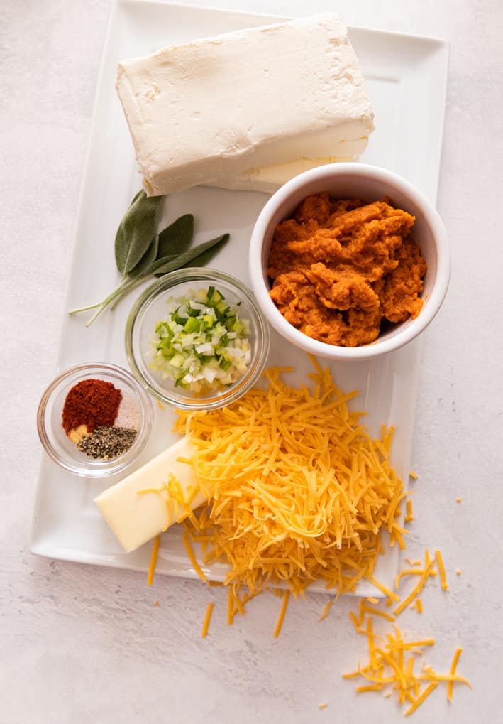 Ingredients for cheese ball. Cream cheese, canned pumpkin, sage, scallions, spices, butter, grated cheese.