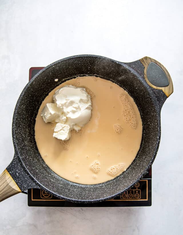 evaporated milk in pot with sour cream and cream cheese ready to melt