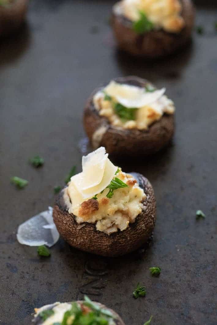 Boursin Stuffed Mushrooms on baking sheet with Parmesan flakes on top.