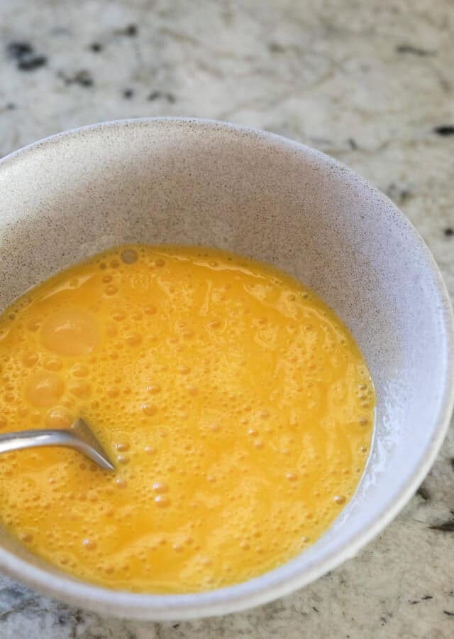 Eggs whisked in a bowl.