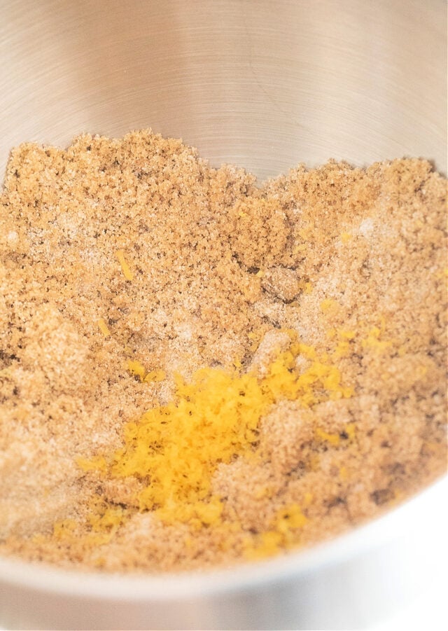 White and brown sugar and lemon zest in a bowl.