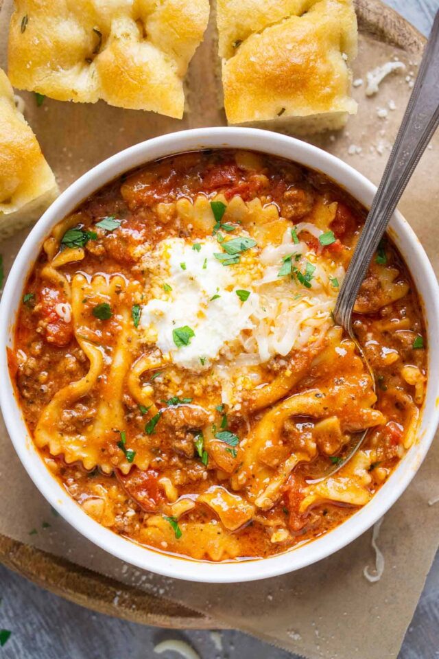 Bowl of lasagna soup with focaccia on side.