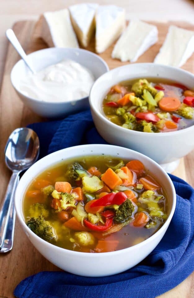 Vegetable Sour Soup in bowls with Creme Fraise in the background.