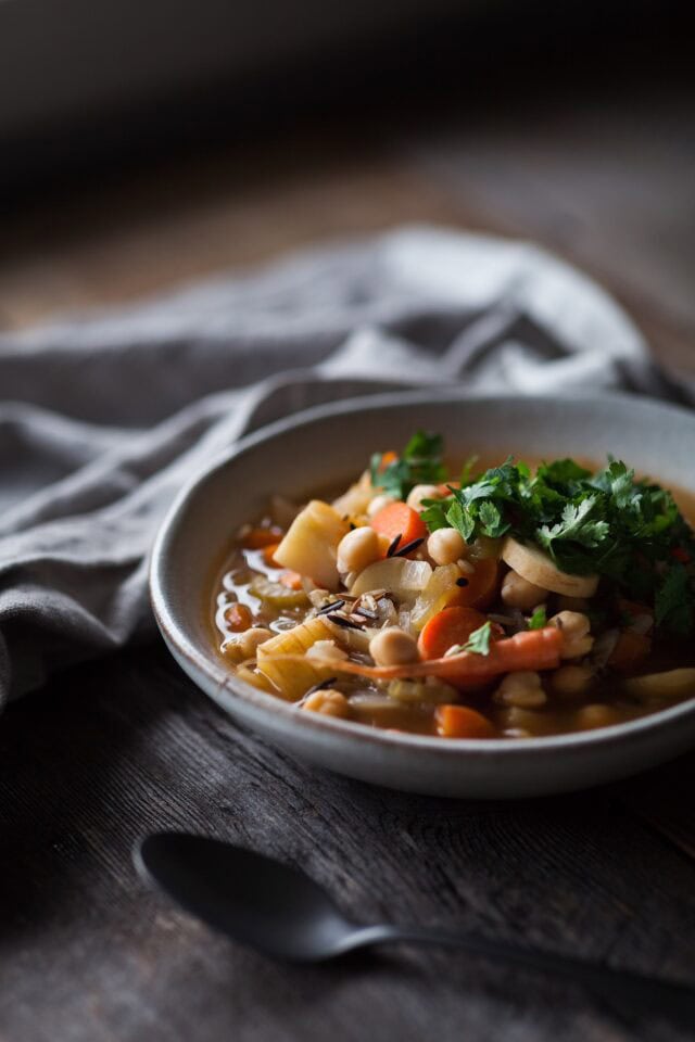 Winter Root Vegetable Soup in bowl with spoon and cloth on side.