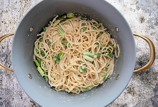 Pot with asparagus and pasta stirred into the cream sauce.