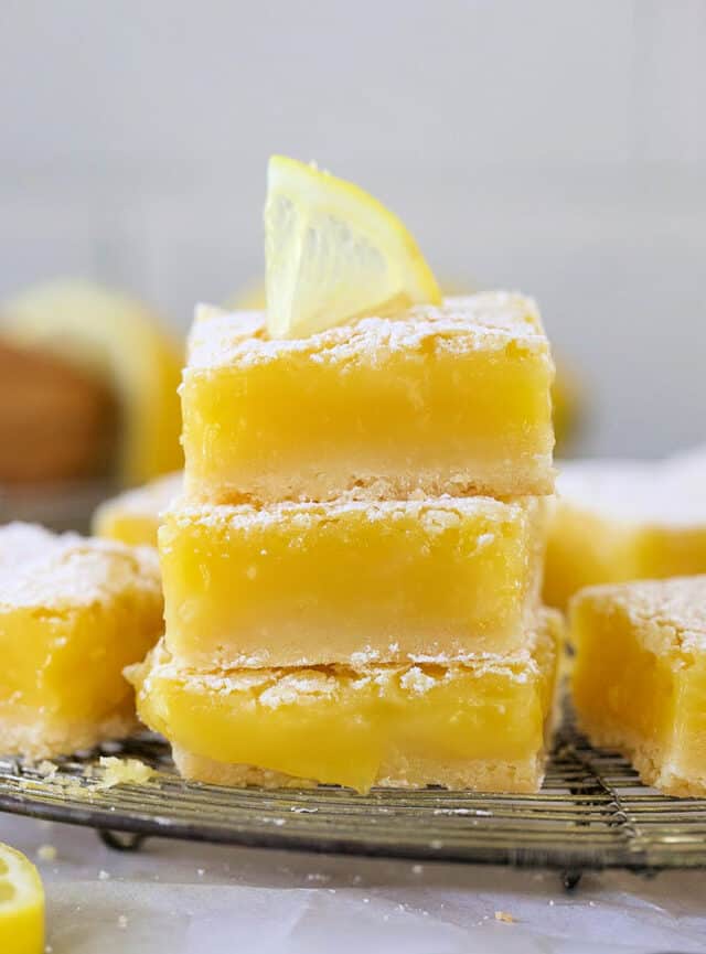 Easy classic lemon bars stacked with a lemon slice on top.