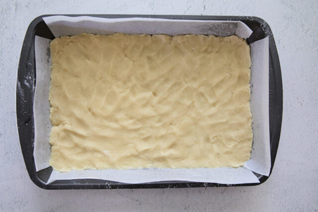 Shortbread crust pressed into pan before baking.