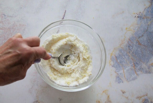 Lemon zest pressed into sugar for homemade lemon loaf