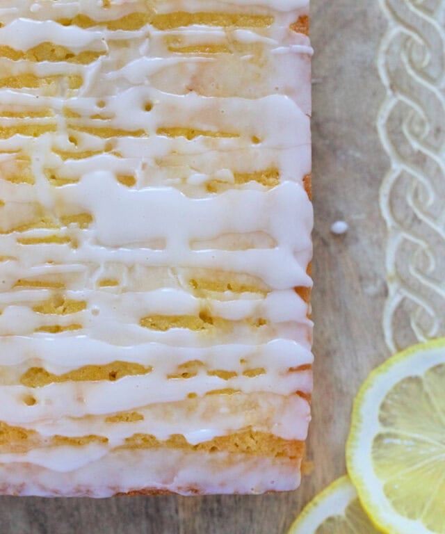 Fresh lemon glaze being drizzled over homemade lemon loaf