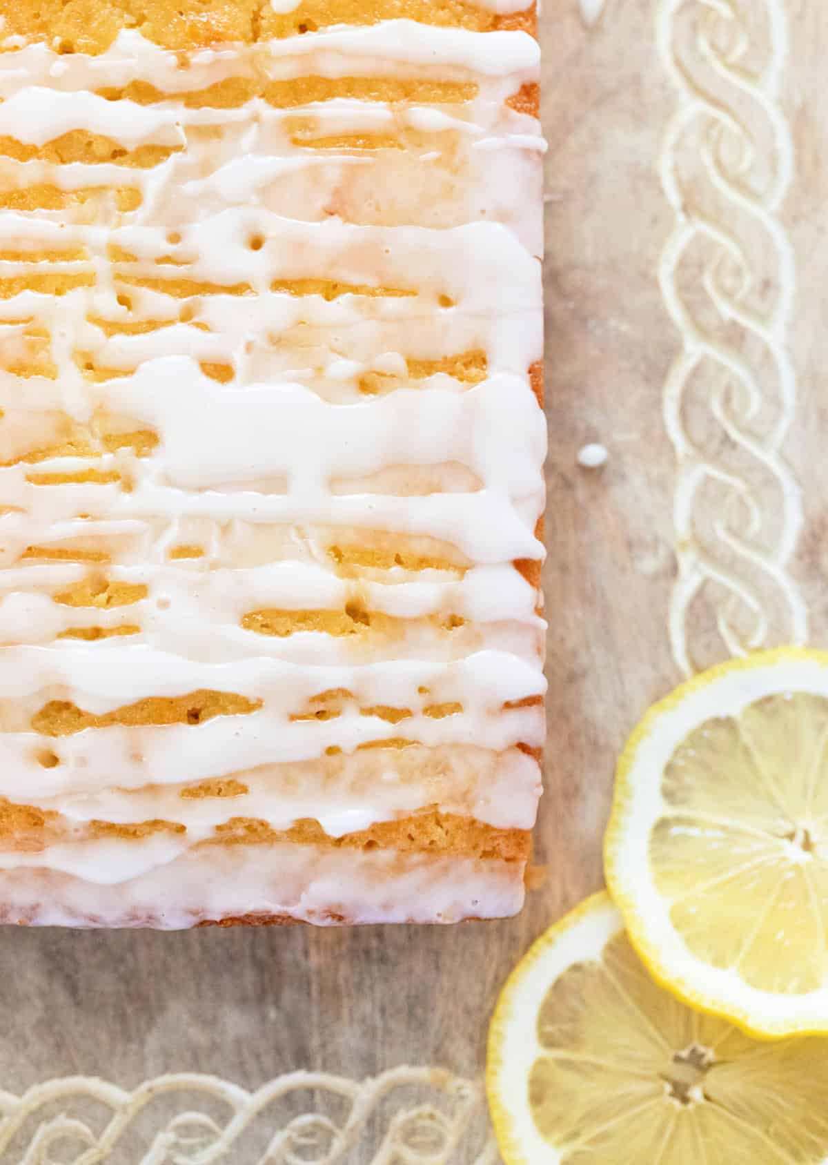 Close up of glazed lemon loaf with lemon slices.