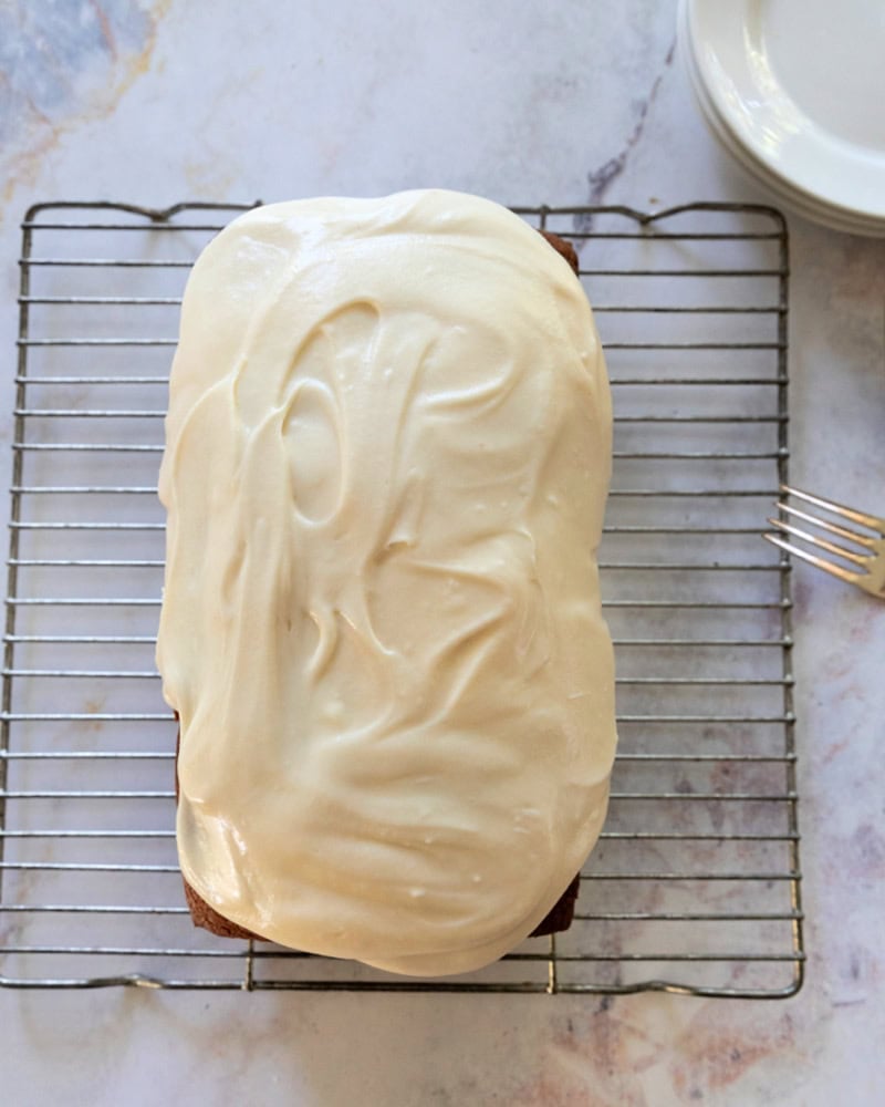 Cooled pumpkin bread with cream cheese frosting on top.