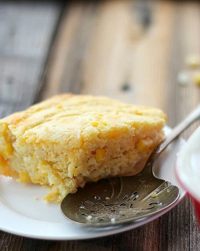 Quick Corn Spoonbread on a white plate with serving spoon