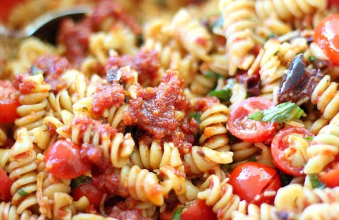 Pasta Salad with Sun-Dried Tomatoes, Basil and Parmesan Cheese, featuring fresh herbs, tomatoes and kalamata olives. Lots of Parmesan, of course!