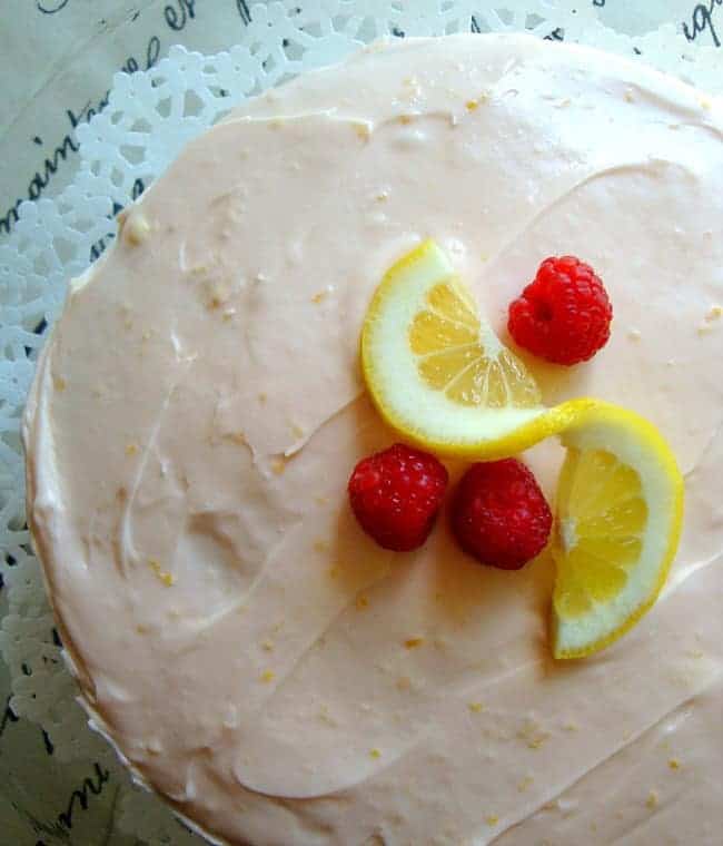 Top view of the Raspberry Lemonade Cake topped with a slice of lemon and three raspberries 