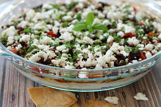 Ultimate Greek 7 Layer Dip in a glass bowl