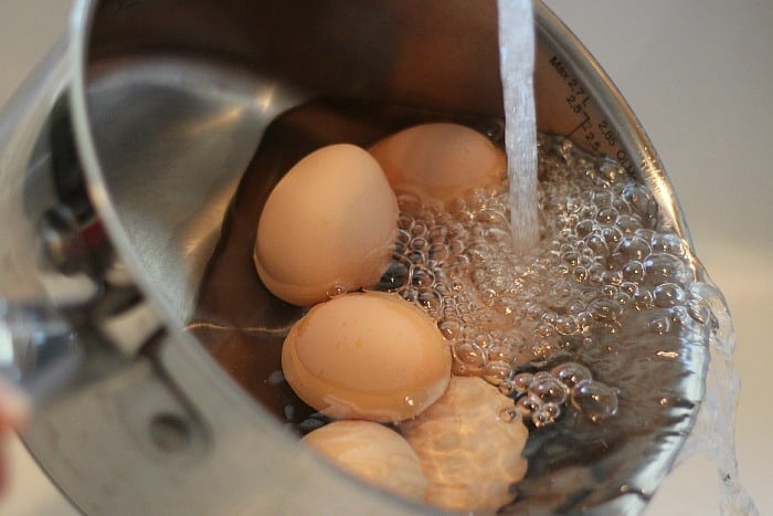 Eggs in a pan, adding cold water