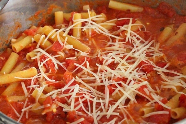  Pasta Sauce and pasta in a pan, sprinkled with parmesan cheese