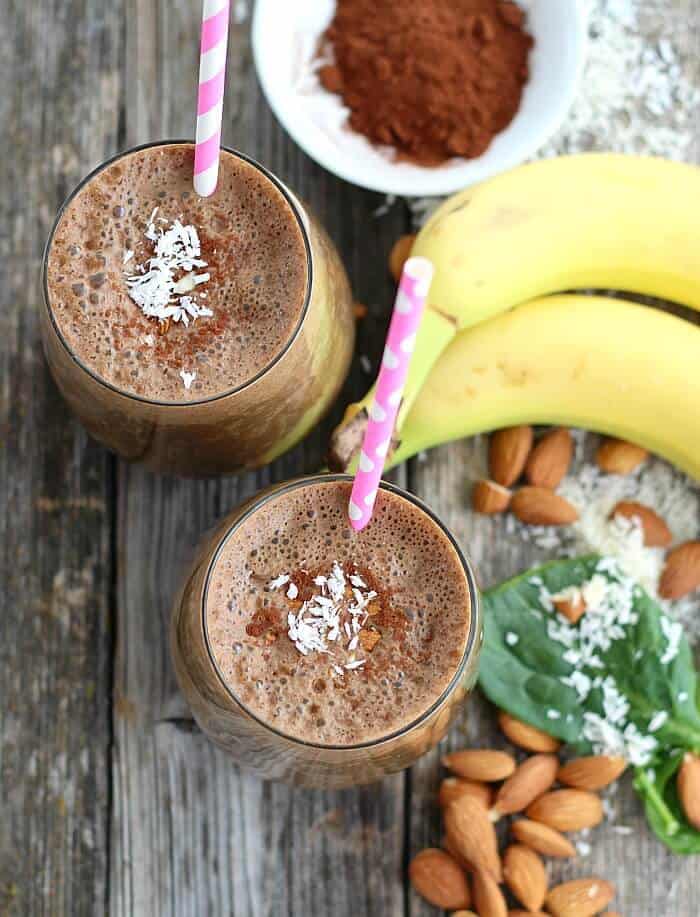 Two glasses of Almond Joy Smoothie with banana, cocoa powder, almonds, and coconut.