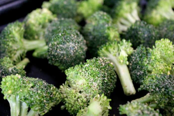 Broccoli florets with seasoning before roasting