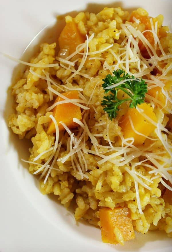 Risotto with butternut squash, sprinkled with Parmesan served in a white bowl
