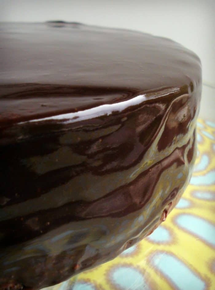 Whole chocolate cake on a blue and yellow plate