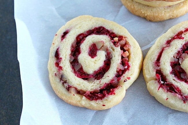 close up view of cranberry walnut swirls on parchment paper