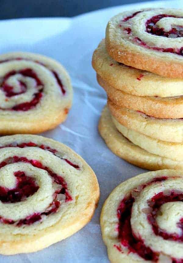 cranberry walnut swirl cookies stacked on top of each other on parchment paper