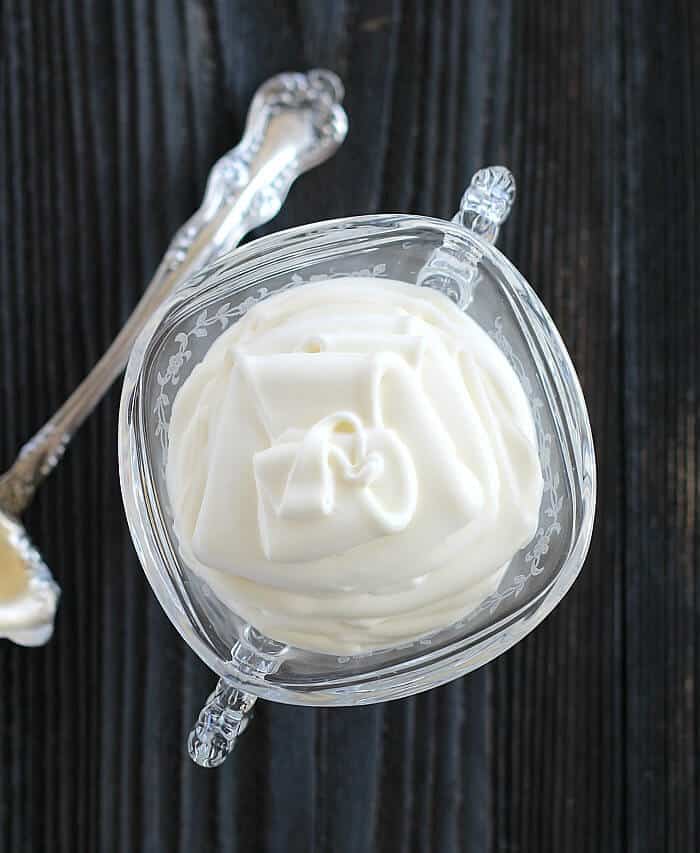 Creme Fraiche in a glass cup with spoon on the side