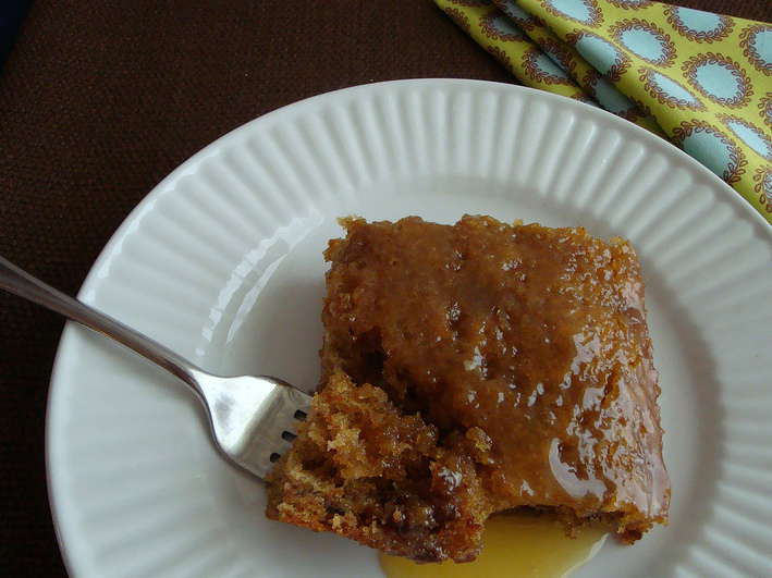 Prune Cake with buttermilk glaze on a white plate with a fork